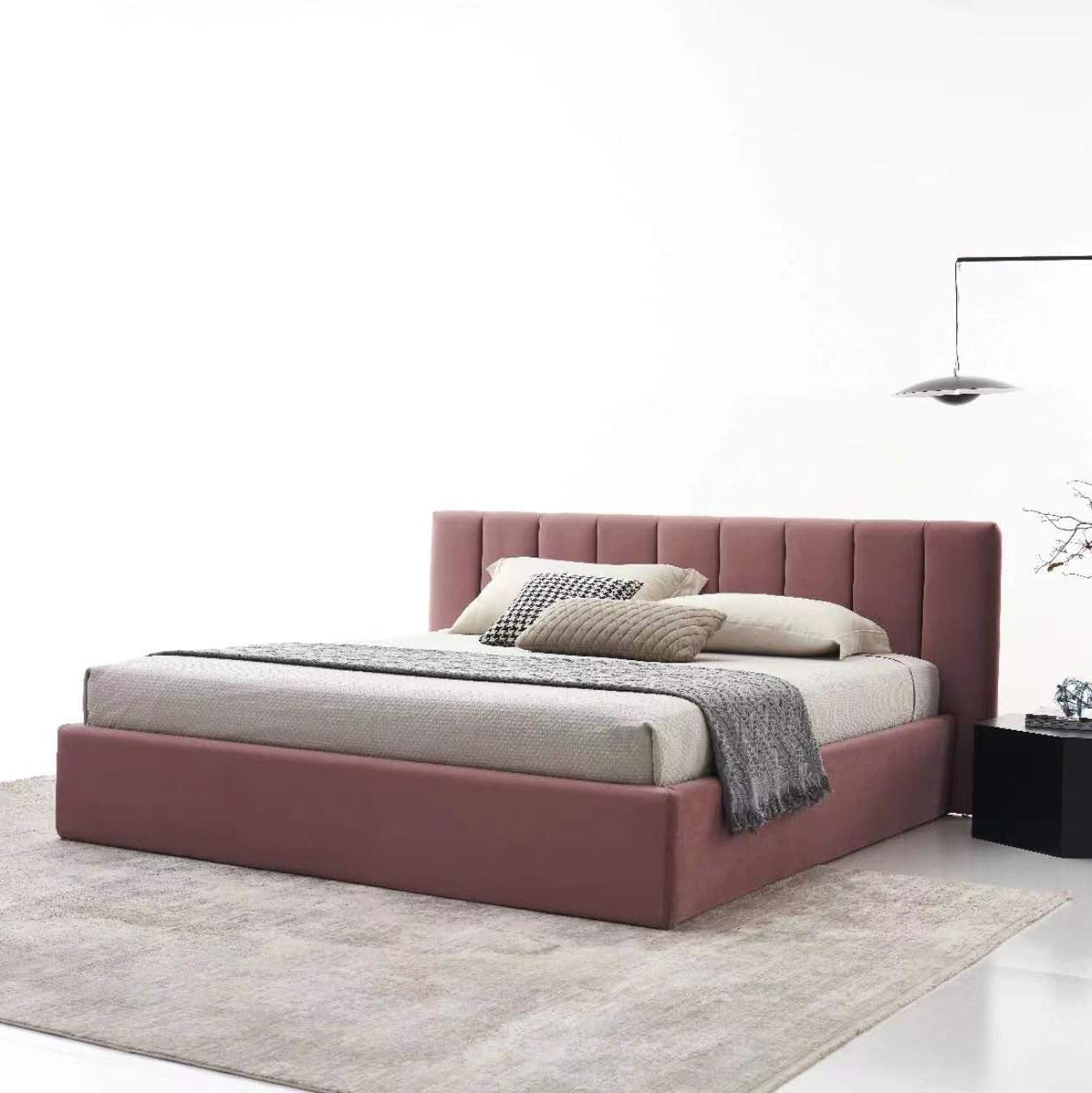 A modern bedroom showcases the Minimalist Solid Wood Upholstered Bed Frame in cream, layered with pillows and blankets. The decor includes a gray rug and a contemporary floor lamp set against a plain white wall.