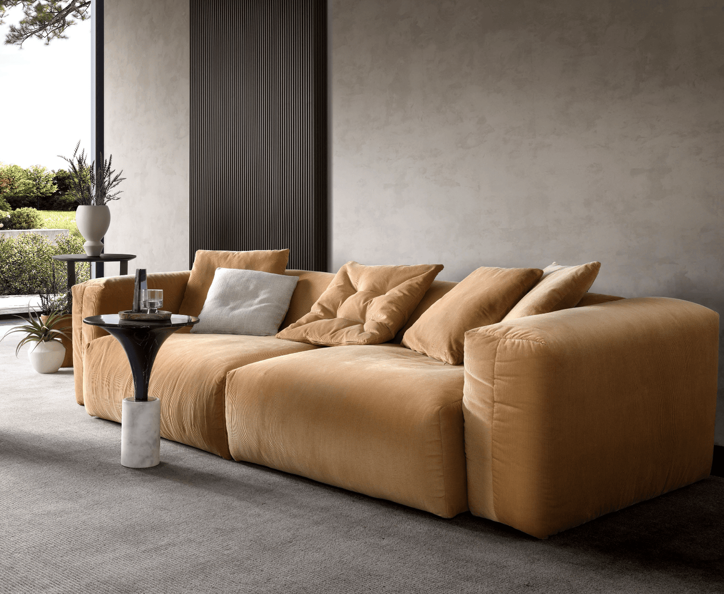 A mustard yellow Loaf Modular Sofa with four matching pillows sits in a modern living room, placed beside a round side table near large windows that offer views of lush greenery.