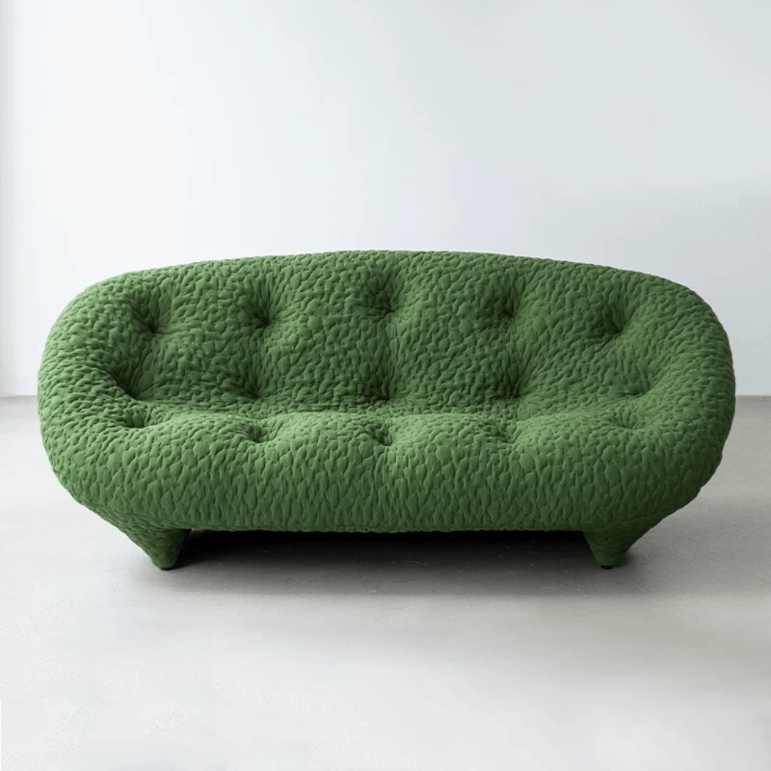 Green Sofa with a rounded design and button-tufted upholstery, set in a minimalist white room.