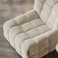 The 休闲椅2, a beige corduroy modular armchair with a quilted, block-like design, is placed on a smooth gray floor.